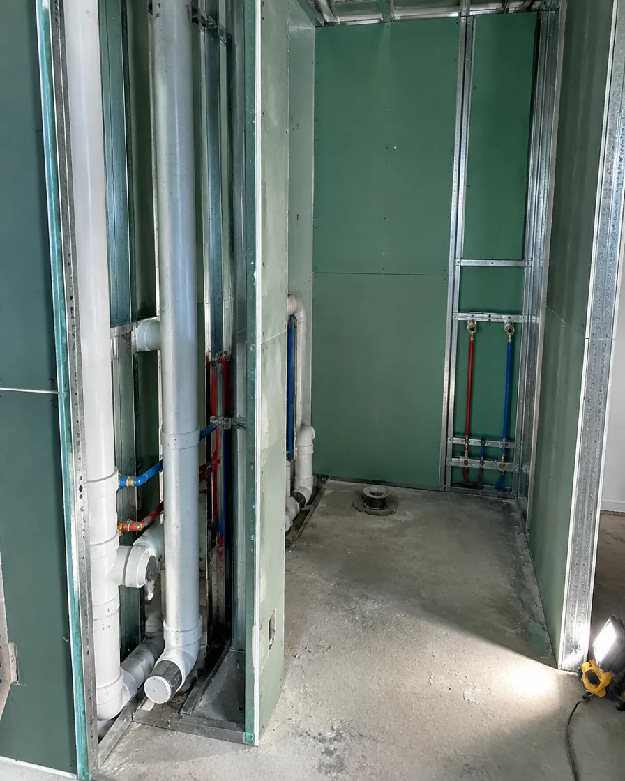 Baño en obra: cañerías a la vista y placas verdes resistentes a la humedad